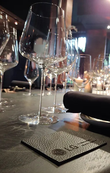 Dining room setting with wine glasses and LG embossed black leather coaster
